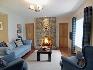 Living room with wood-burning stove and wooden floor | Ardbhan Croft, Oban, near Argyll