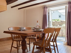 Beamed dining area with doors to the courtyard | Woodlands, Laugharne, near Pendine