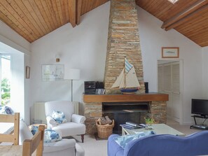 Delightful open plan living space with feature fireplace and wooden ceiling | Topsail, Noss Mayo