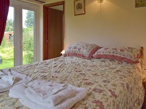 Comfortable double bed with French doors to garden | Mickrandella, Rollesby