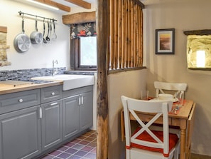 Dining area and kitchen separated by exposed wooden feature wall | The Old Stable, Barber Booth, near Edale