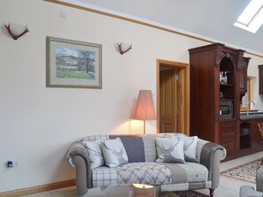 The open plan living area boasts a vaulted ceiling | Turin Nurin Cottage, Tomatin, near Inverness