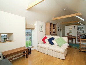 The beamed living/dining room has wooden floors and exposed stone work | Tullibole Castle Longhouse, Crook of Devon