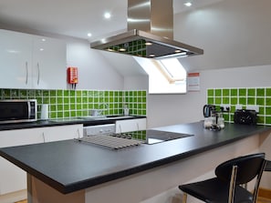 Lovely tiled splashbacks and clean modern fittings in the kitchen area | The Loft, Ciliau Aeron, near Aberaeron
