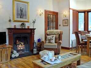 Warm and welcoming living/dining room with open fire | The Gate House, Markinch, near Glenrothes