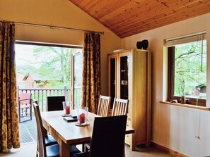 The dining table is next to a set of patio doors that open onto the terrace | Rowanburn Lodge, Greystoke, near Penrith