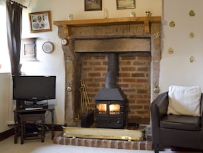 Feature fireplace in living room with wood-burner | Ivy Cottage, Aldwark, near Matlock