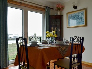 Homely dining area boasting loch views | Bute Cottage, Daliburgh, South Uist