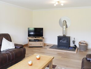 The spacious living room boasts a wood-burning stove  | March Cottage, Glen Cassley, near Lairg