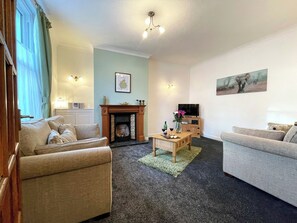 Comfortable living room with an open fireplace | Lavender Cottage, Keswick