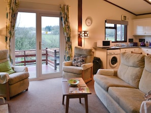 Living area with patio doors to elevated decked area | Catbank - Threapland Park, Moota, near Cockermouth