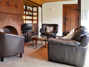 Delightful living room with feature brick fireplace | Summer House, St Asaph