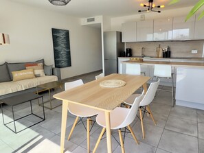 Coin repas et cuisine ouverte sur le salon avec vue mer sur la baie d'Ajaccio