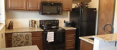 View of the kitchen with granite counters, upgraded cabinets, heated floor, etc