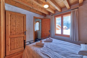 Rez de chaussée Chambre des maîtres avec lit double menant à la salle de bains.