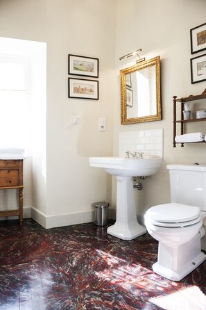 The sunny bathroom features a handpainted marbleized floor. Tres chic!
