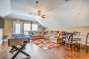 Enjoy this upstairs bonus room with 4K TV, foos ball table, and comfy couch.