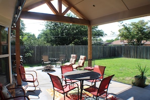 Beautiful patio with fan, lights seating and a large yard.