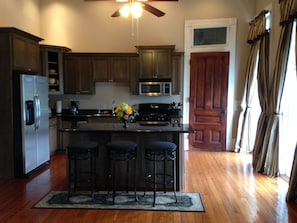 A closer view of the kitchen showing bar stools at the island.