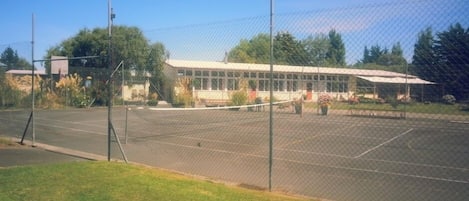 Looking across the tennis court to the school. The apartment is behind the tall birch tree