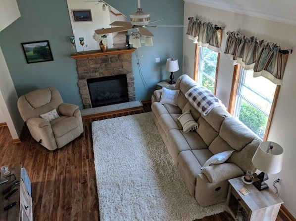 Enjoy this cozy living room with reclining  seating, electric fireplace, largeTV