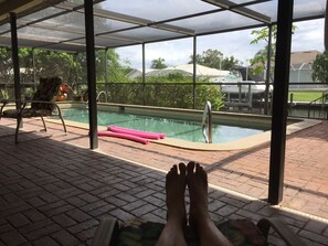 Relaxing in the reclining lanai chair, poolside, overlooking canal. 