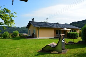 Ansicht Ferienhaus mit Relaxliege und Grillplatz