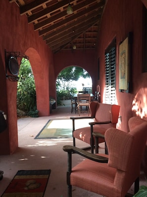 Covered entry porch leads to poolside and beach