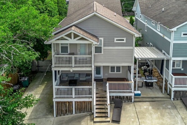 Driveway wraps around back with 2 story decks and covered grill area, hot tub, outdoor TV firepit