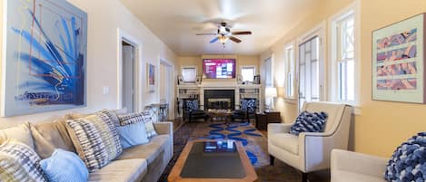 Livingroom with dual seating areas, 65" smart tv and queen sleeper sofa.