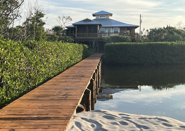 A boardwalk across a small tidal lagoon leads to the beach and dune sundeck.