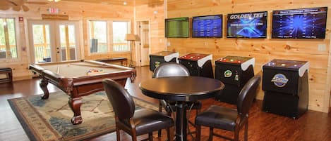 Game room with seating, arcade cabinets, and a pool table.