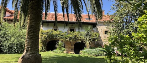 Fachada sur, vista del jardin frontal al porche