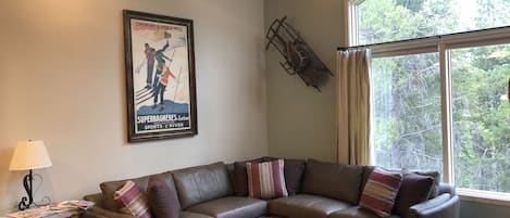 Living room with new furniture, vaulted ceiling, three sided fireplace