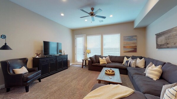 Family room featuring large flat screen tv and door to patio