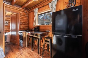 The cooking area boasts a versatile stove top/oven combo, a spacious refrigerator with a convenient freezer, and a well-equipped coffee pot, ensuring all your culinary needs are met with style and convenience.