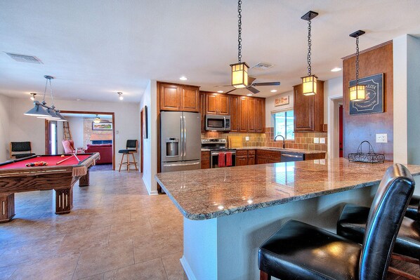 Large fully stocked kitchen with pool table and bar