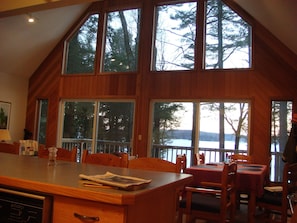 View of lake through window, table for 6 on right, 4 bar stools at counter