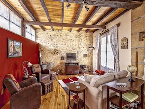 Beautiful living room area with a wood burning stove, TV, DVD and a Music Player