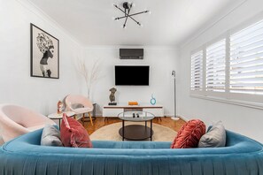 Beautiful living room with Daikin A/C , plantation shutters, and 50inch TV