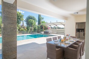 Shaded outside dining area with table and chairs to seat 8 people
