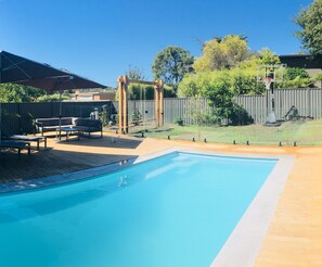 The backyard is highlighted by the Pool. 

Basketball ring has been removed.