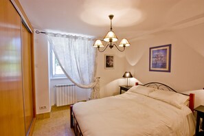 Bedroom of apartment 4 with queen sized bed, matching bedside tables & wardrobes