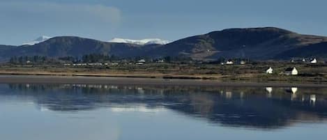 Snow capped mountain reflection on beach at Waterville