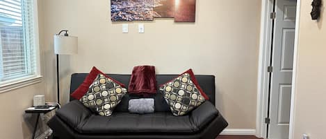 Living space with sofa bed. Bathroom entry to the right.