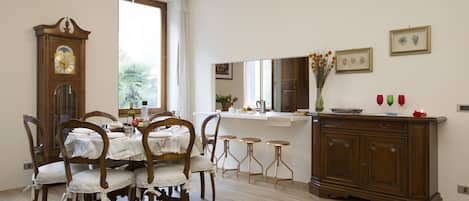 The living room with dinner table, pendulum clock and the counter