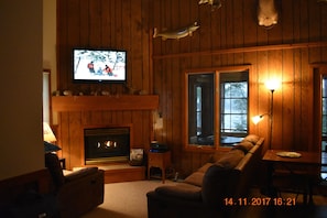 Cozy living room with fireplace and large screen TV.
