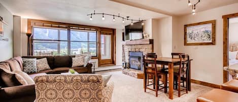 Living room with view of seating, fireplace, TV and the Sunroom