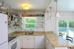 Kitchen with granite countertop and slider to pool