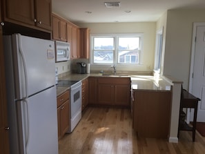 Kitchen w/ updated granite countertops open to oceanviews and living space.